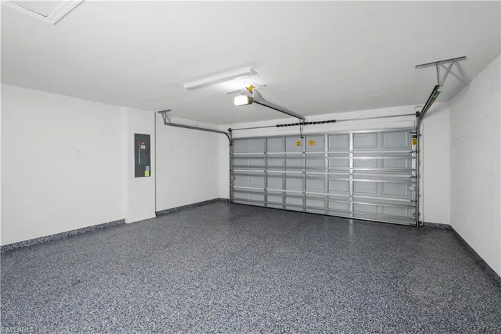 Garage with an epoxy floor, white walls, and a panel-style garage door
