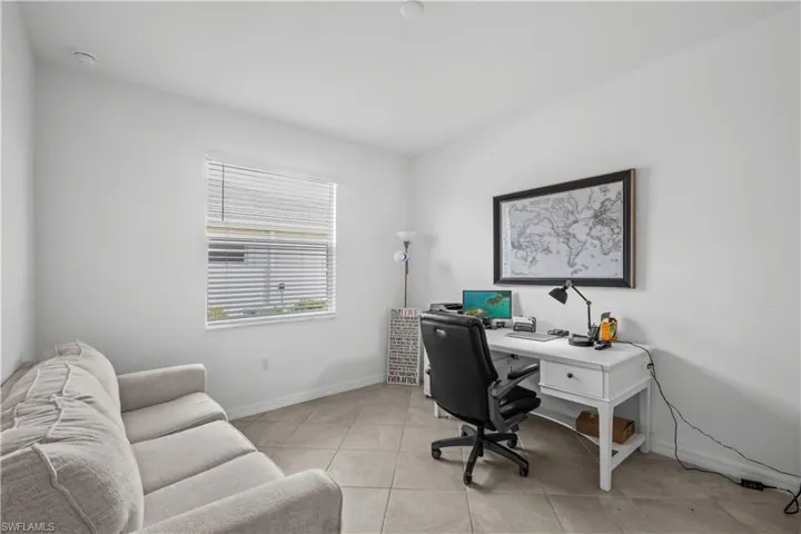 Neutral-toned tile flooring, white painted walls, and a window with horizontal blinds