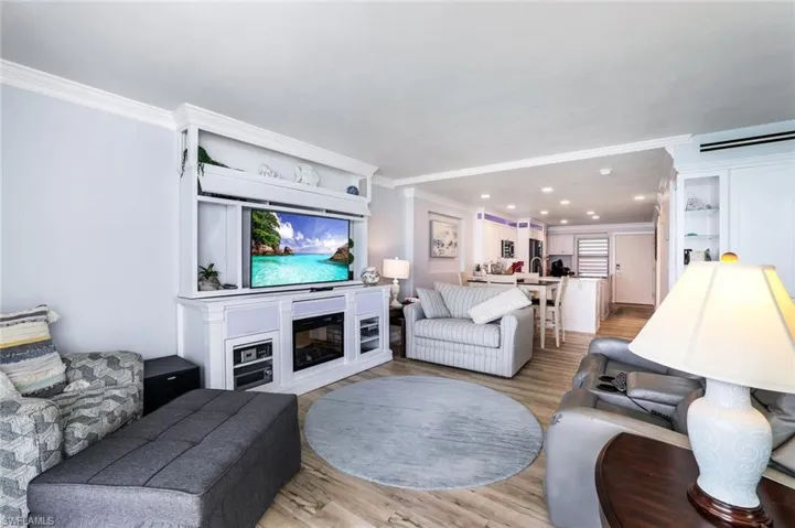 Living room featuring sink, crown molding, and wood-type flooring