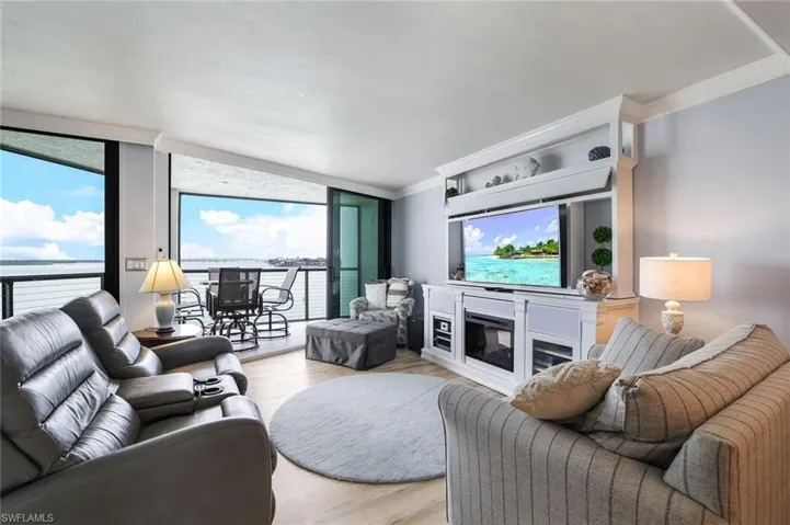 Living room with ornamental molding, light hardwood / wood-style flooring, and a water view