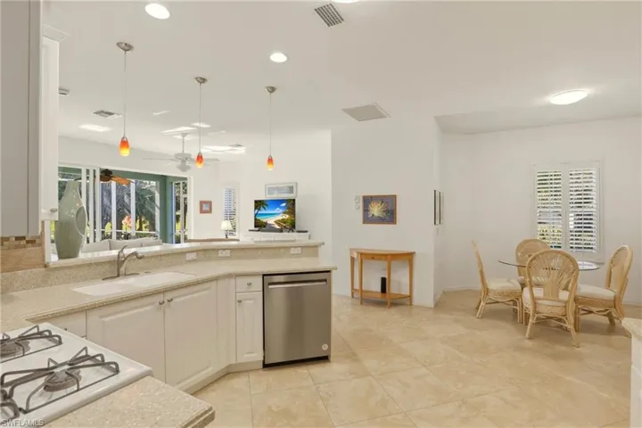 Kitchen featuring pendant lighting, white gas cooktop, dishwasher, a ceiling fan, and a peninsula
