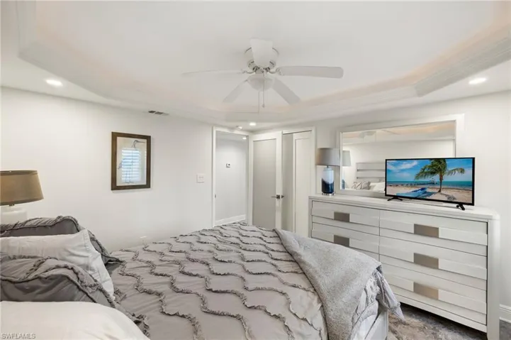 Bedroom with ceiling fan, ornamental molding, and a raised ceiling