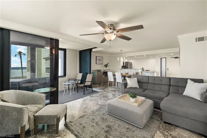 Living room with ceiling fan and ornamental molding