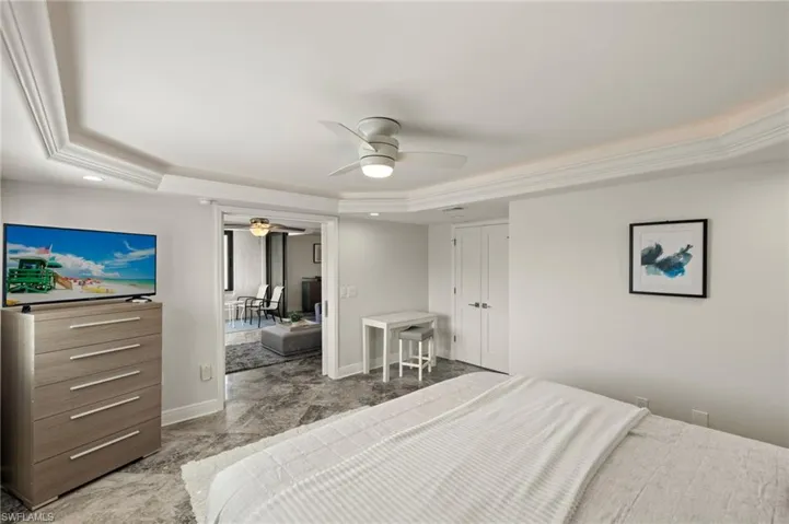 Bedroom with ceiling fan, ornamental molding, and a raised ceiling