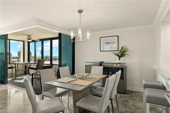 Dining space featuring expansive windows, crown molding, and a chandelier