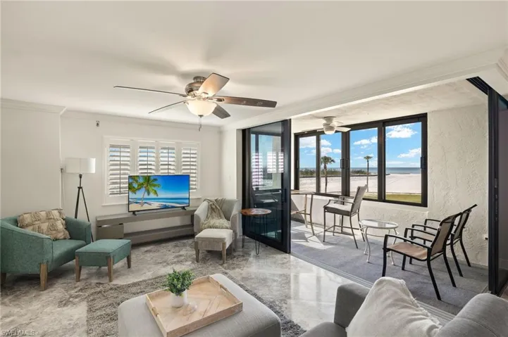 Living room with ornamental molding and ceiling fan