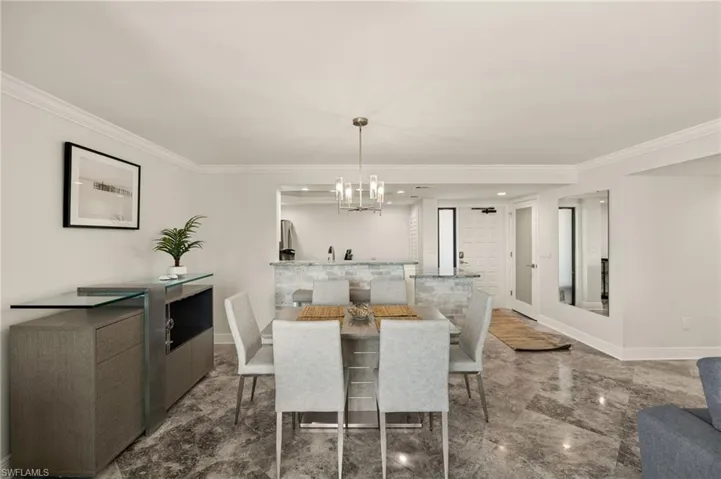Dining area with crown molding and a chandelier