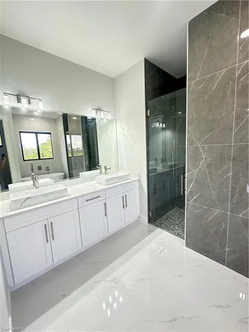 Bathroom with a shower with shower door and vanity