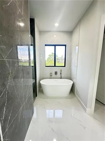 Bathroom featuring tile walls and a bathing tub