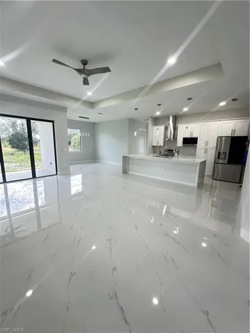 Unfurnished living room with sink and ceiling fan