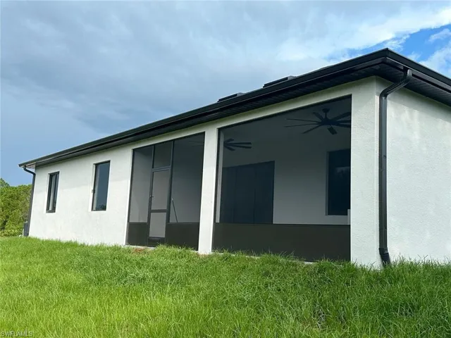 View of home's exterior featuring a lawn and a sunroom