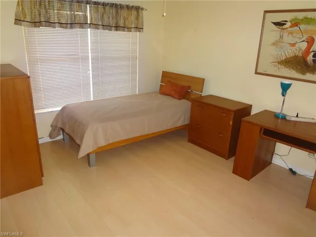 Guest bedroom featuring hardwood/wood-style floors & ceiling fan