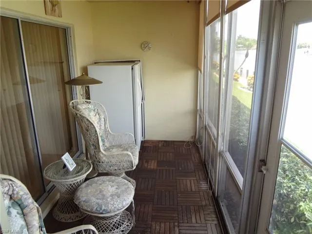 View of screened lanai with extra refrigerator and sun shades