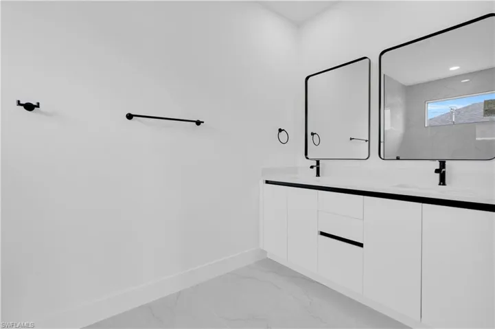Full bathroom with double vanity and light marble finish flooring