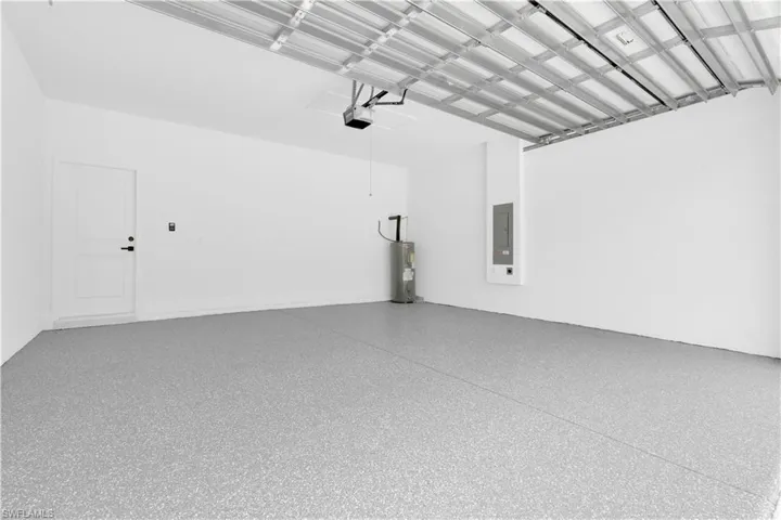 Garage featuring electric panel and water heater