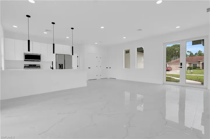 Unfurnished living room featuring light marble finish flooring and recessed lighting