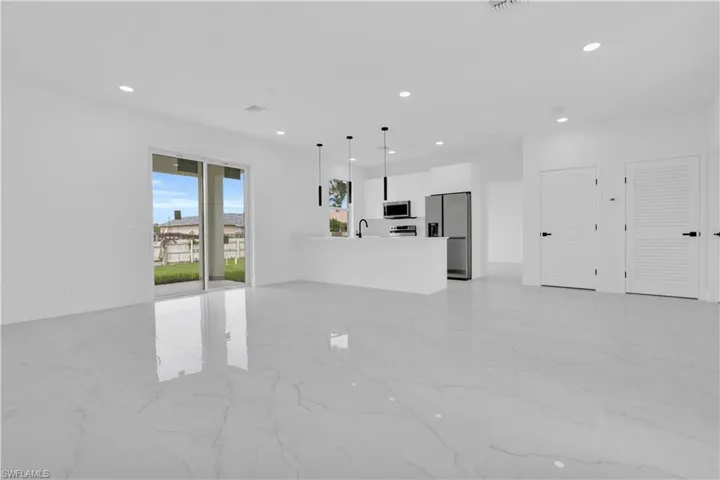 Unfurnished living room with light marble finish floors and recessed lighting