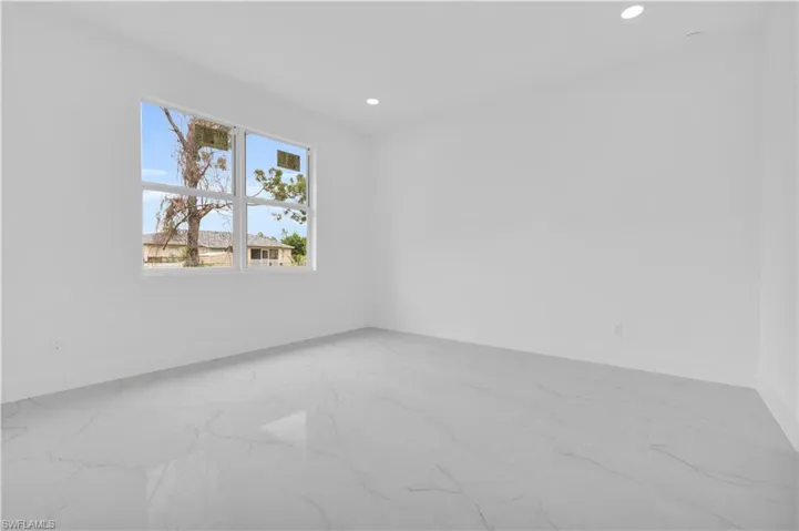 Spare room featuring light marble finish floors and recessed lighting