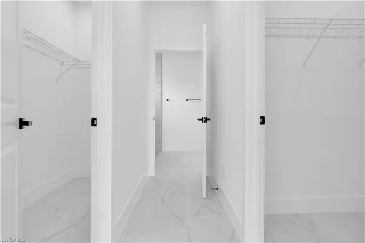 Walk in closet featuring light marble finish flooring