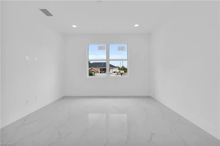 Unfurnished room with light marble finish floors and recessed lighting