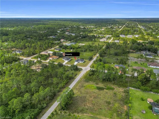 Aerial view of property's location with a forest and nearby suburban area