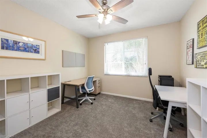 Bedroom featuring newer carpet and vaulted ceiling with fan.  Currently staged as office