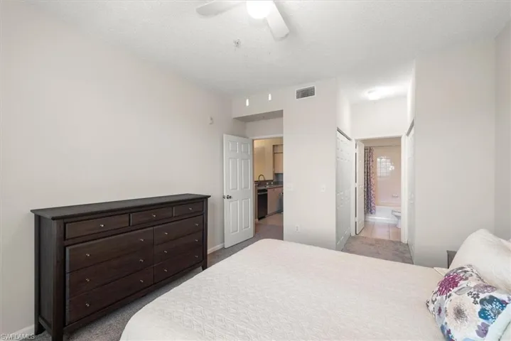 Primary Bedroom with newer light carpet, ceiling fan, and connected bathroom
