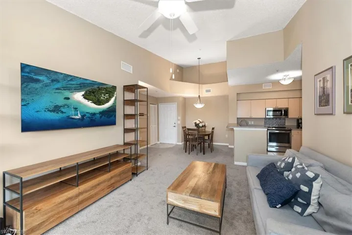 Living area with new light carpet, vaulted ceiling and fan