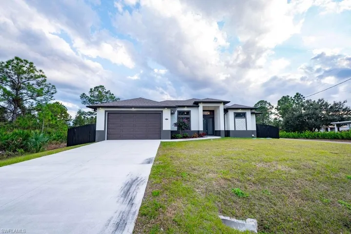 Prairie-style house featuring stucco siding, concrete driveway, and an attached garage