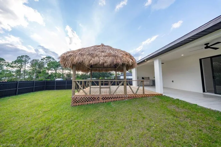 Fenced yard with a gazebo, a wooden deck, and a ceiling fan