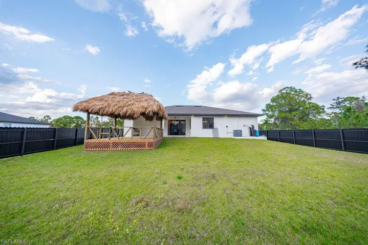 Rear view of house with a fenced backyard, a wooden deck, and stucco siding