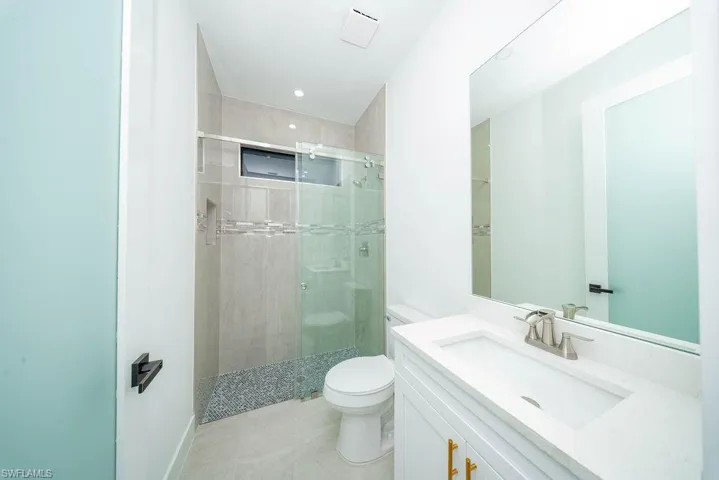 Full bath with vanity, a stall shower, and recessed lighting
