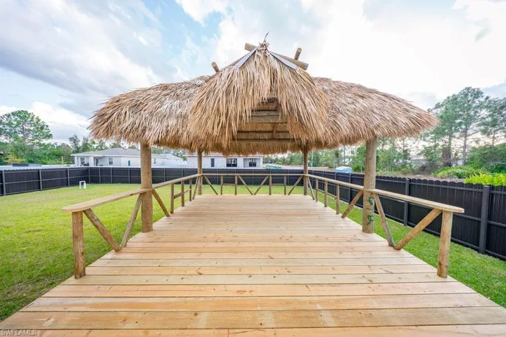 Wooden terrace with a fenced backyard