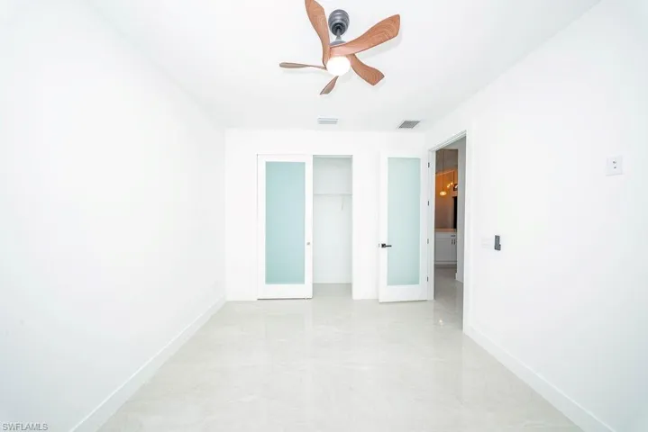 Unfurnished bedroom with ceiling fan and a closet