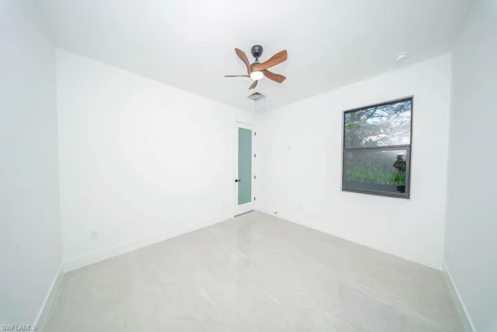 Unfurnished room with baseboards and a ceiling fan