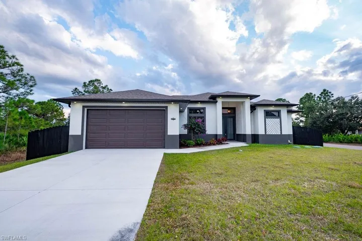 Prairie-style home featuring stucco siding, driveway, and a garage