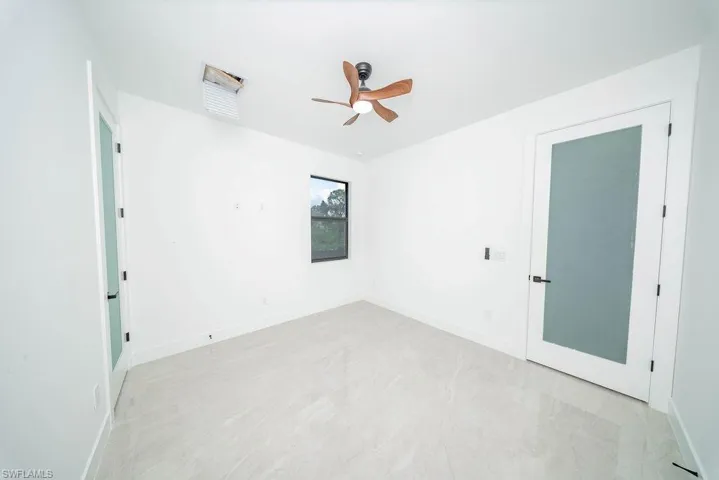 Empty room featuring baseboards and a ceiling fan
