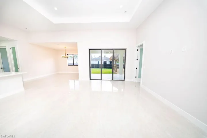 Spare room with a chandelier and baseboards