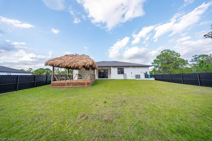 Back of property with a wooden deck, a fenced backyard, and stucco siding
