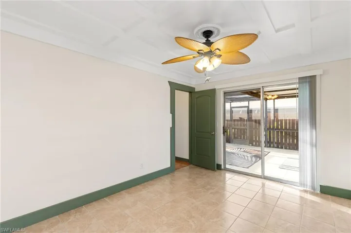 Tiled spare room featuring ceiling fan and coffered ceiling