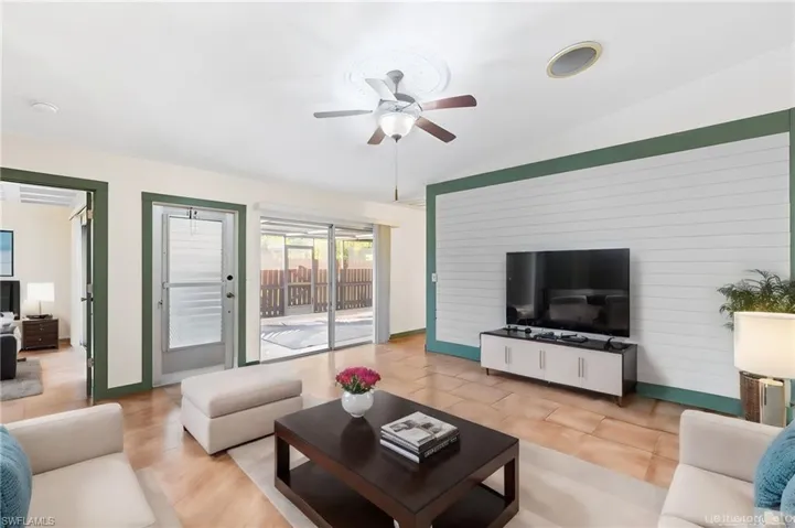 Tiled living room featuring vaulted ceiling and ceiling fan