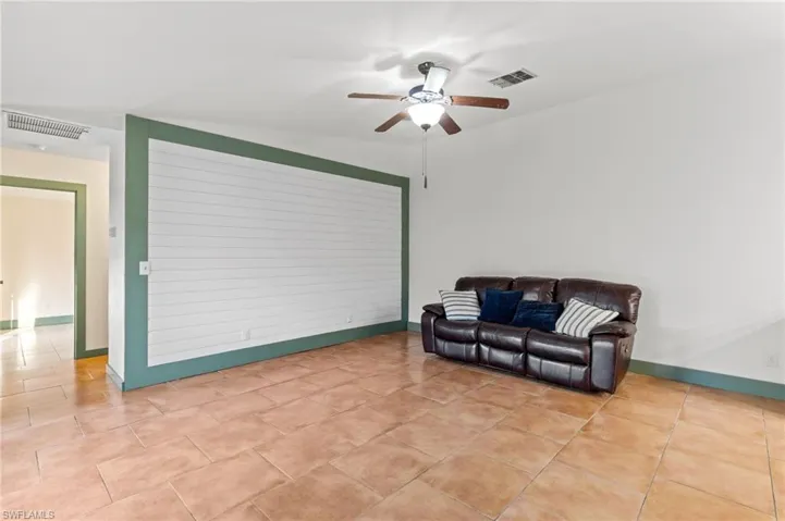 Living area with light tile patterned floors and ceiling fan