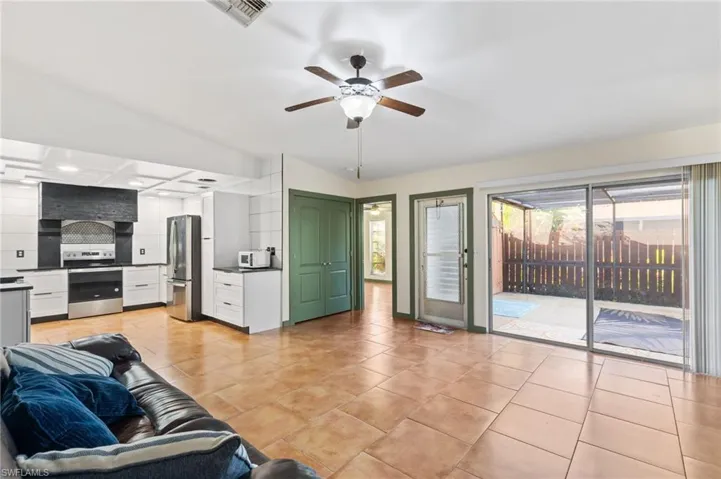 Tiled living room featuring vaulted ceiling and ceiling fan