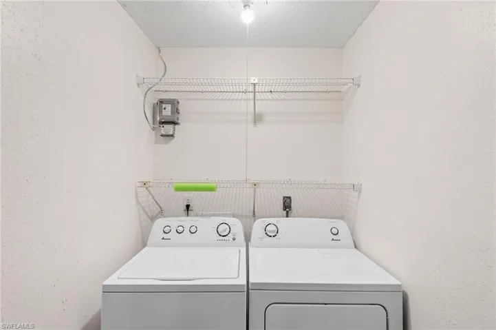 Washroom with separate washer and dryer and a textured ceiling