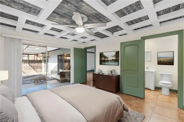 Tiled bedroom featuring access to exterior, connected bathroom, coffered ceiling, and ceiling fan