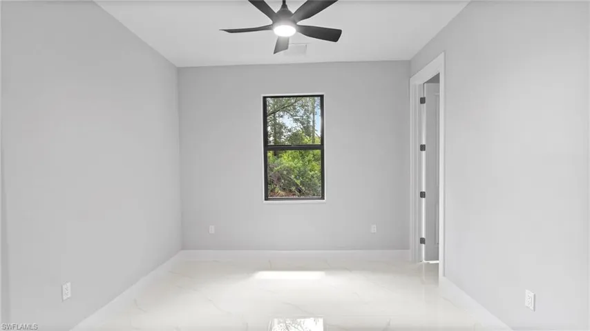Unfurnished room featuring marble tiled flooring and ceiling fan