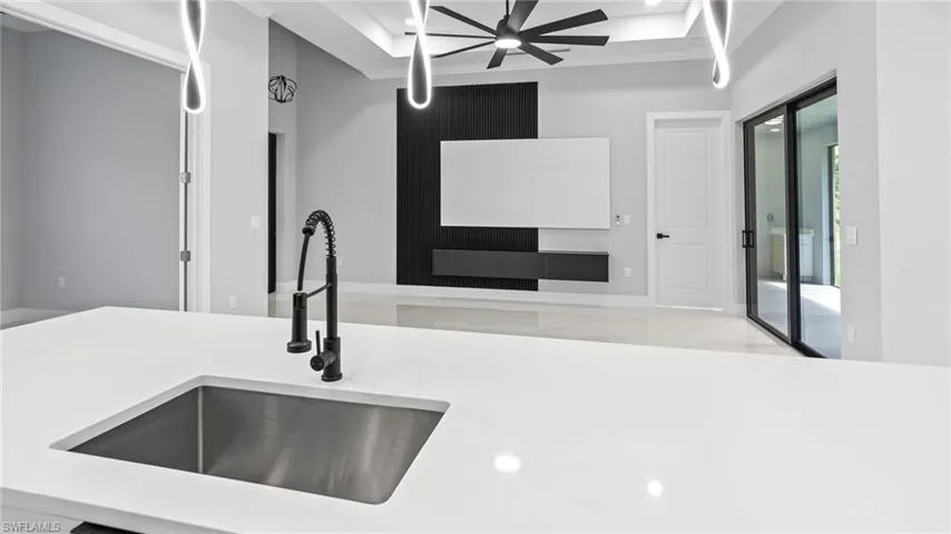 Kitchen view of ceiling fan, light countertops, and recessed lighting