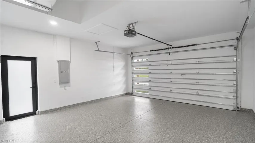 Garage featuring electric panel and a garage door opener