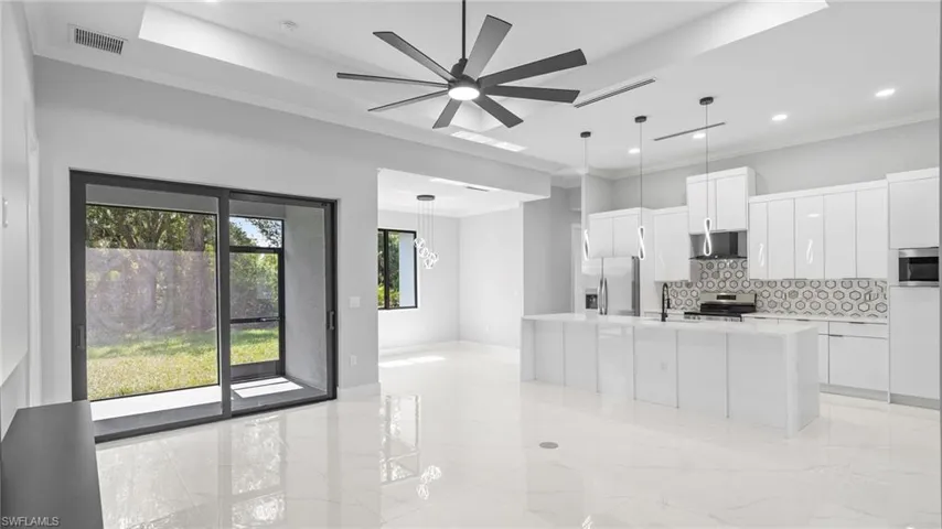 Kitchen featuring appliances with stainless steel finishes, backsplash, white cabinets, light countertops, and recessed lighting