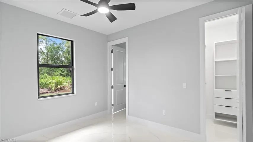 Unfurnished bedroom with light marble finish flooring and a ceiling fan